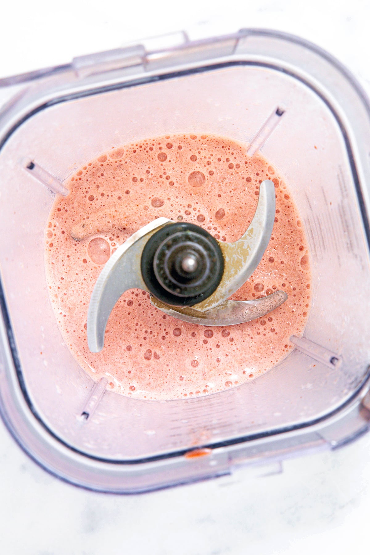 Overhead view of a blender with strawberry shortcake Frappuccino.