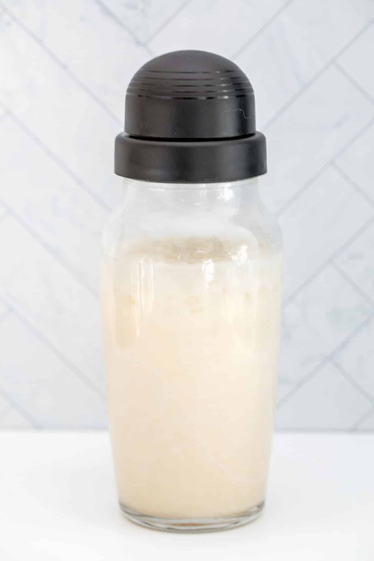 Sugar cookie martini mixture in a clear cocktail shaker.