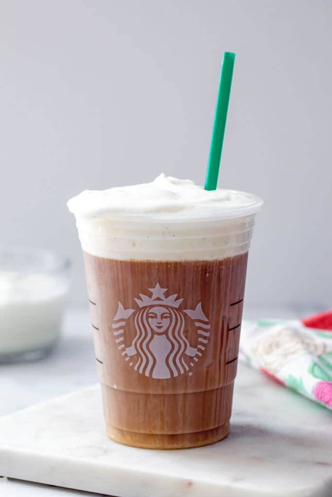 Head-on view of a Starbucks cup filled with cold brew and topped with a sweet cream cold foam.