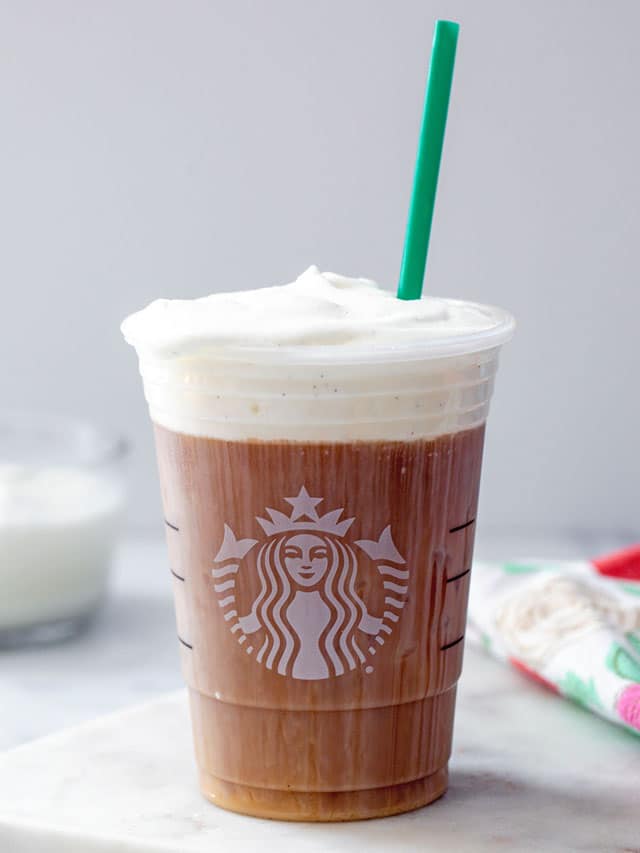 Head-on view of a Starbucks cup of cold brew with sweet cream cold foam on top.