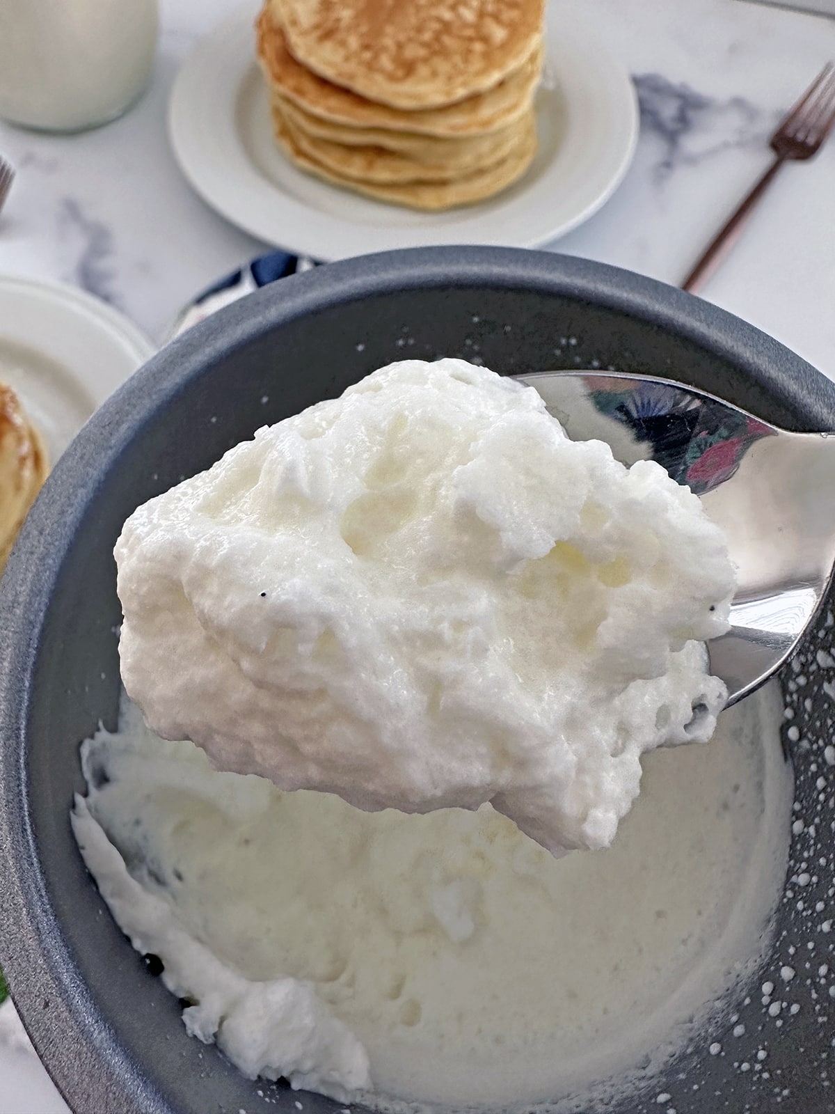 Sweet cream cold foam on spoon.