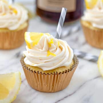 Closeup view of a sweet tea vodka cupcake with lemon wedge and straw.