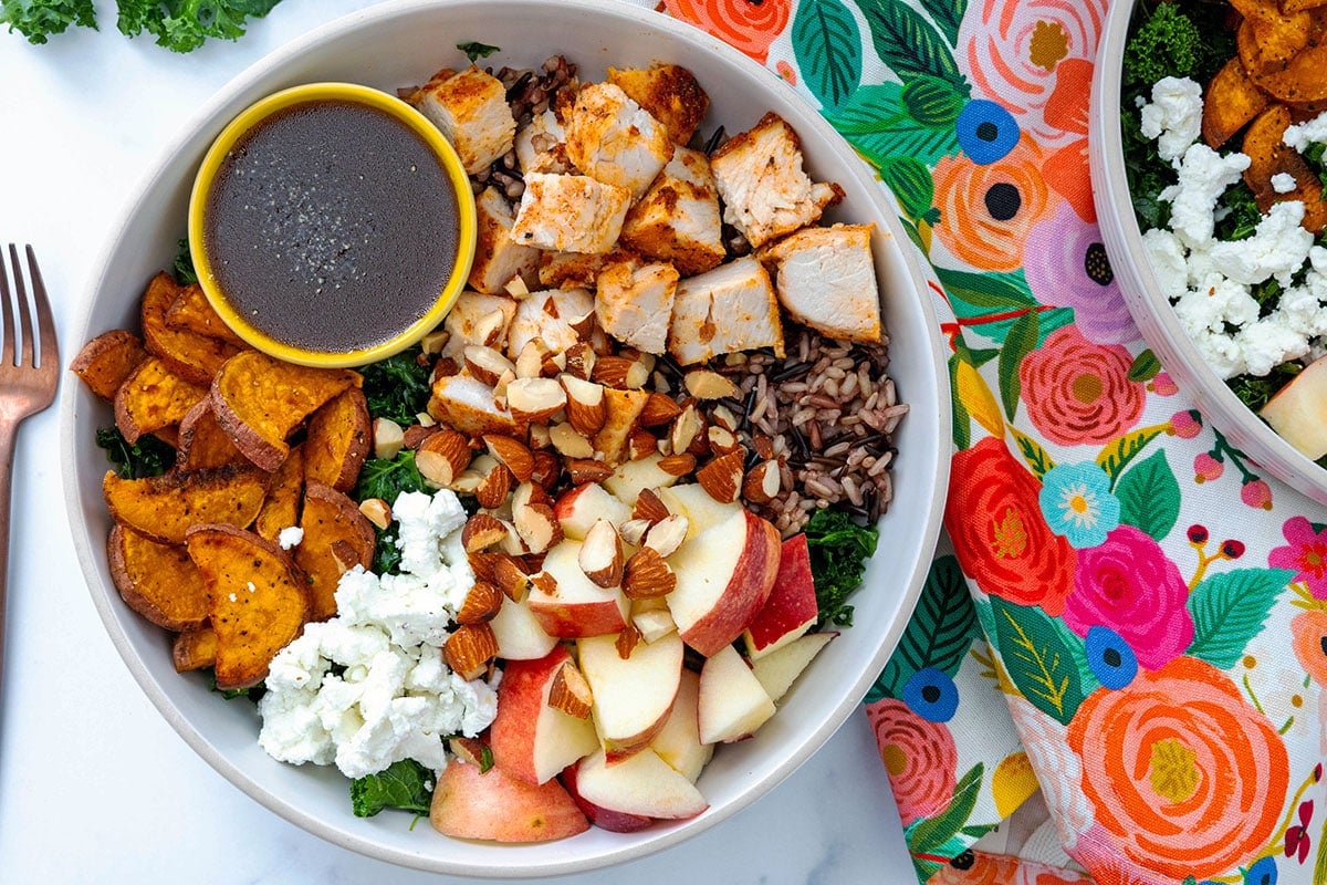 Overhead landscape view of a Sweetgreen Harvest Bowl with fork and second bowl in background.