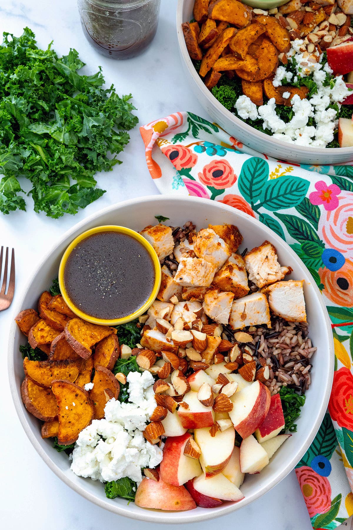 Overhead view of a Sweetgreen Harvest Bowl with kale, sweet potato, apples, chicken, rice, and dressing.