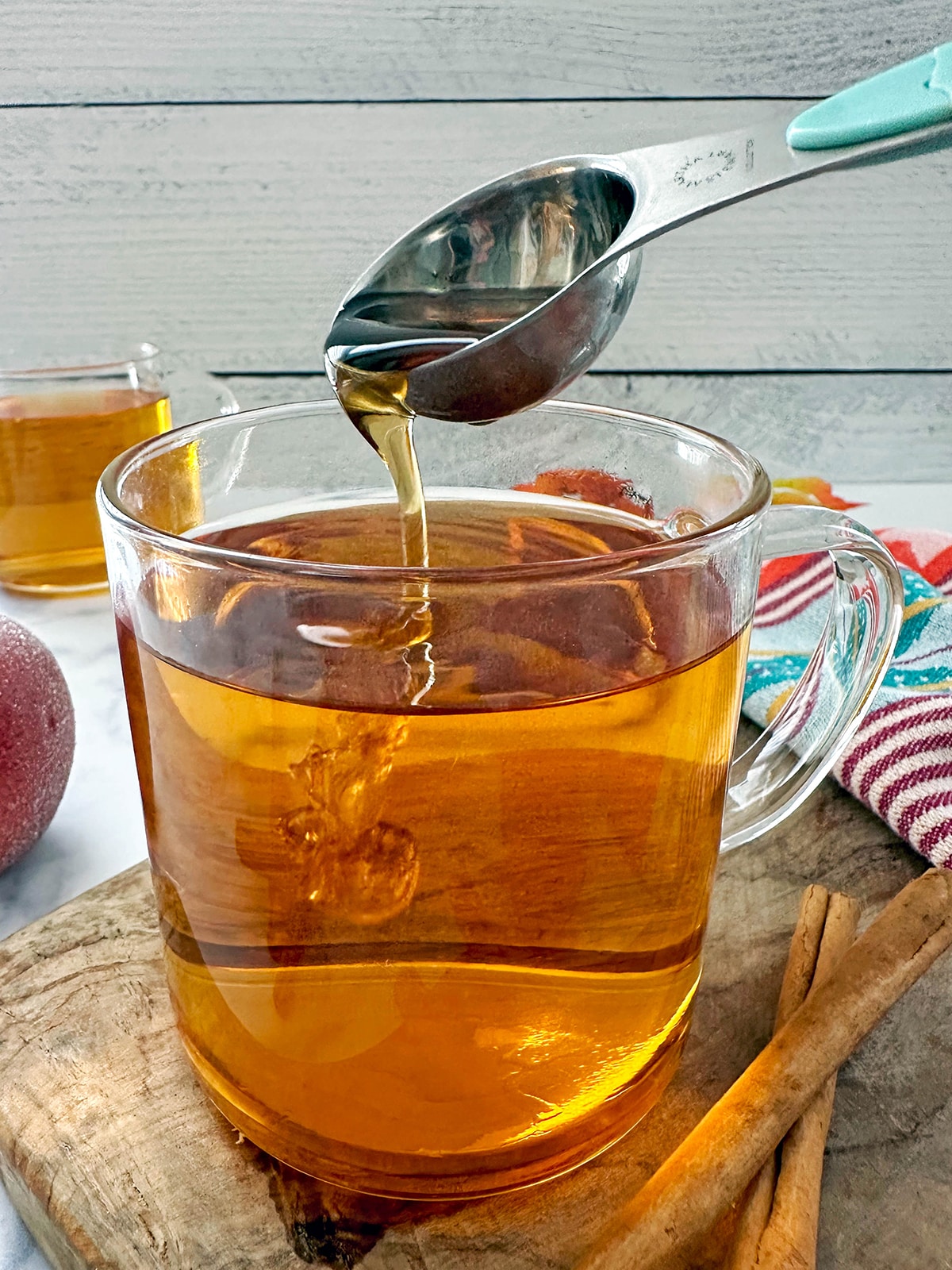 Syrup being sponned into steamed apple juice.