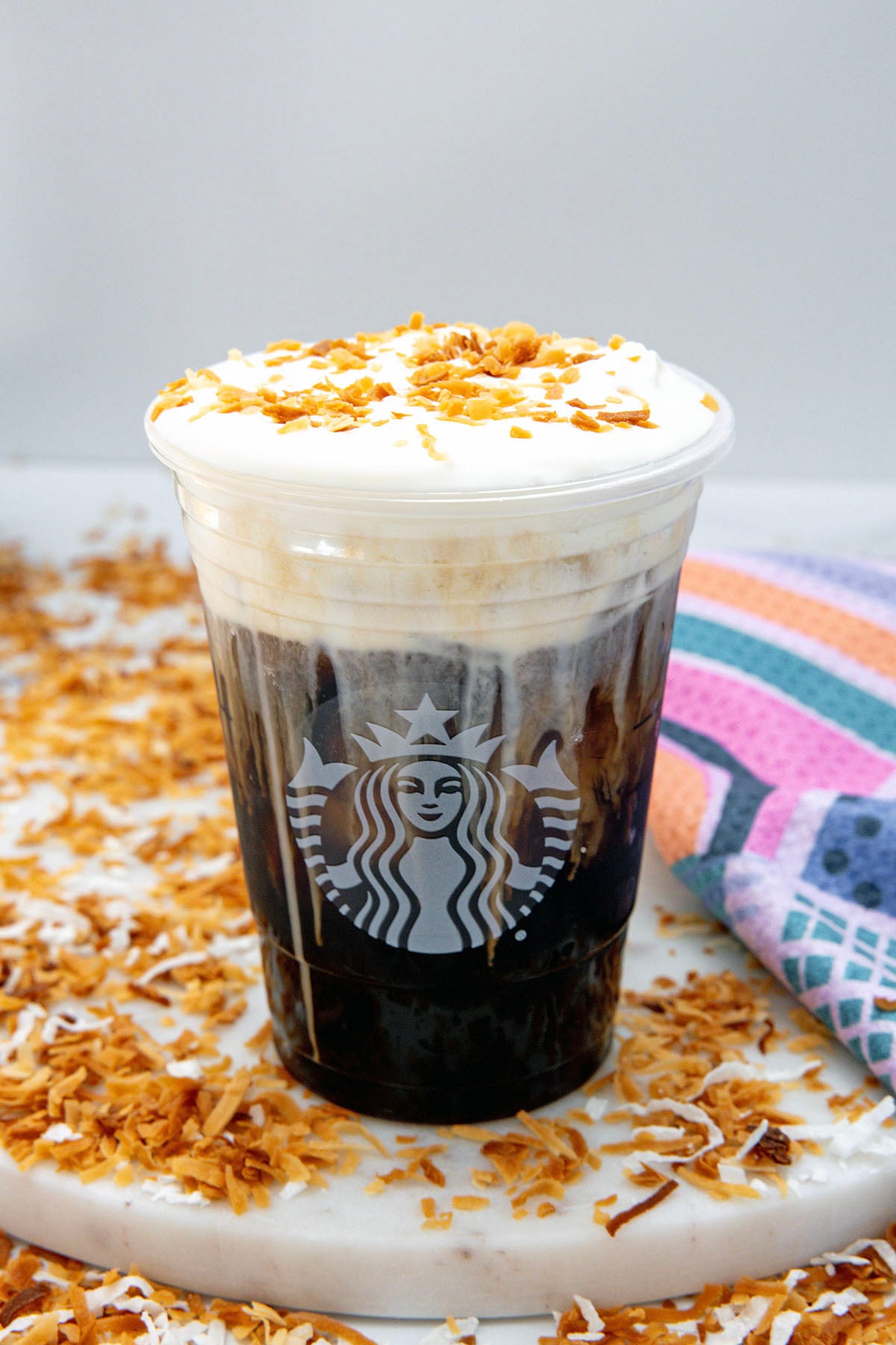 Overhead view of a toasted coconut cream cold brew with cold foam and toasted coconut on top.