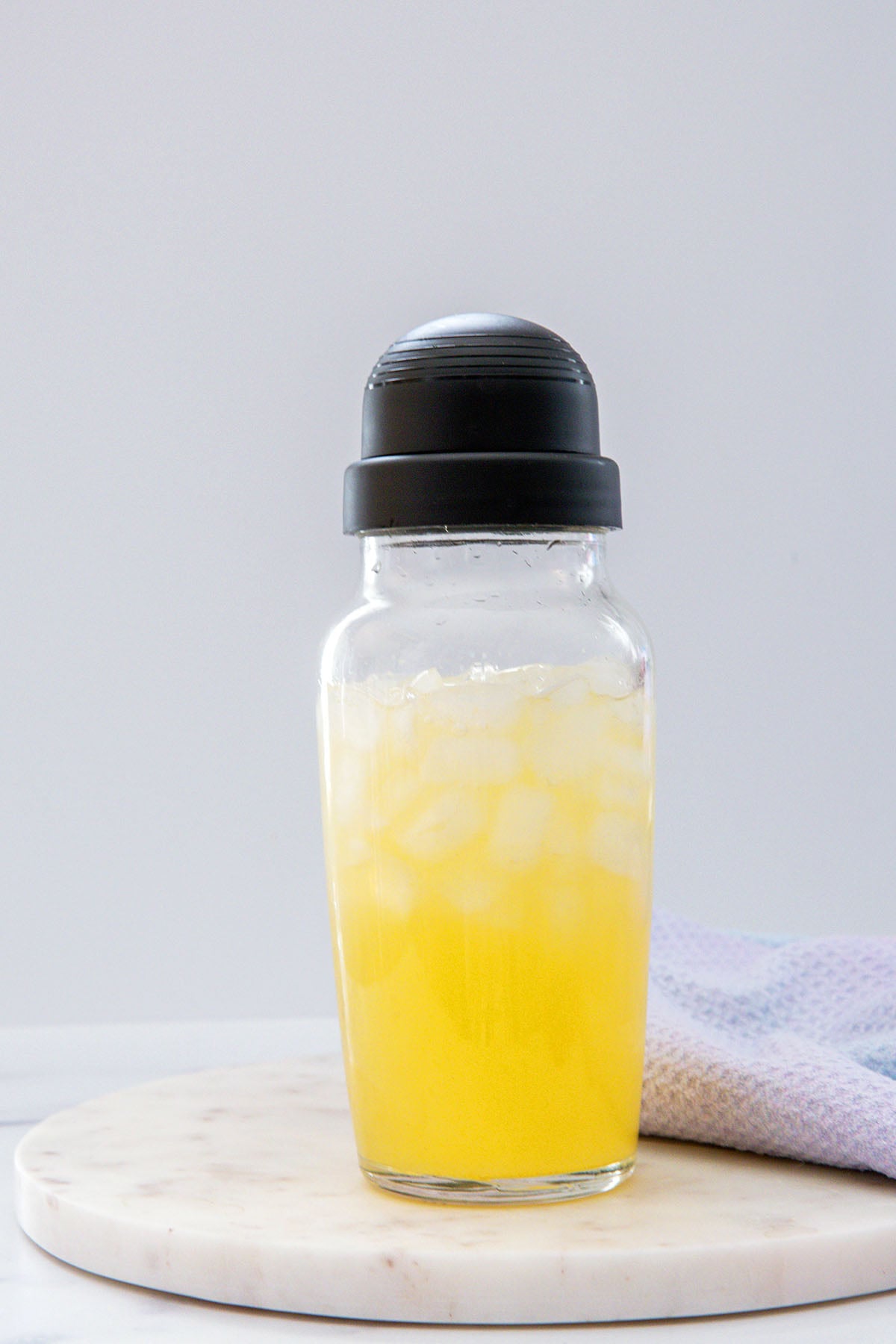 Head-on view of Tropical Butterfly Refresher base mixed with water in clear shaker.