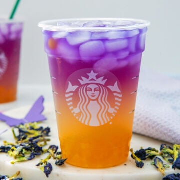 Closeup view of an orange and purple Tropical Butterfly Refresher in Starbucks cup.