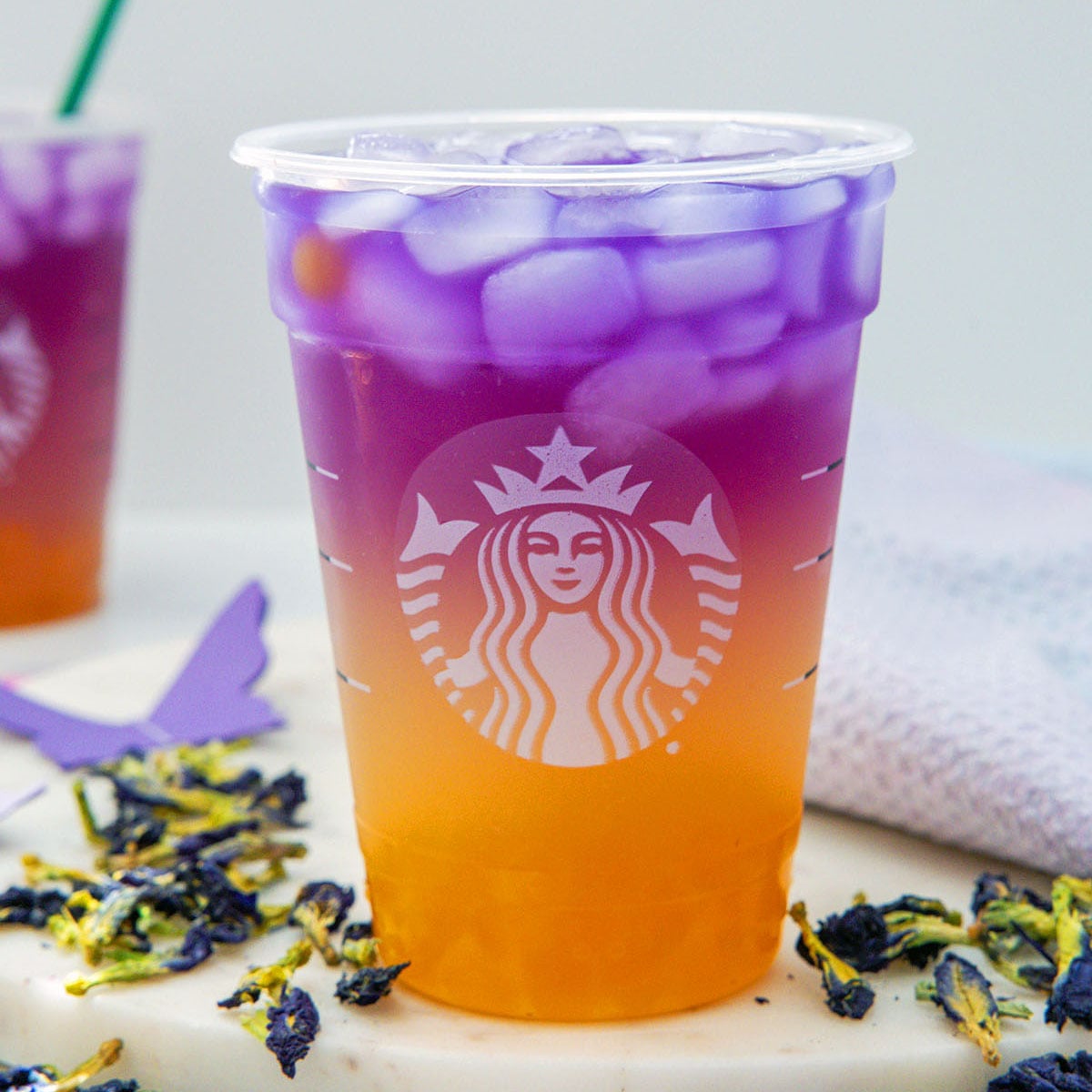 Closeup view of an orange and purple Tropical Butterfly Refresher in Starbucks cup.