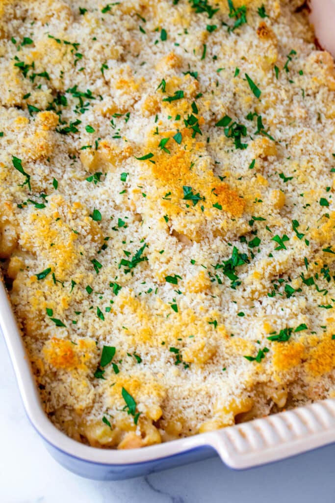 Cooked mac and cheese topped with parsley in casserole dish.