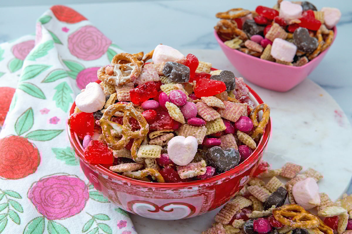 Landscape head-on view of a bowl of Valentine snack mix with second bowl in background.
