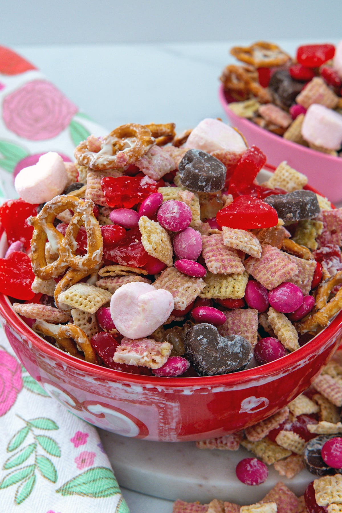 Closeup head-on view of Valentine snack mix in a red and white bowl.