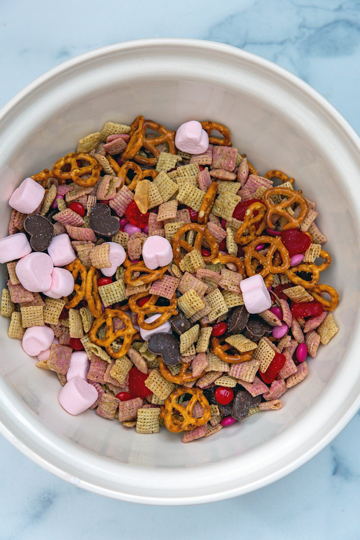 Valentine snack mix ingredients mixed together in mixing bowl.