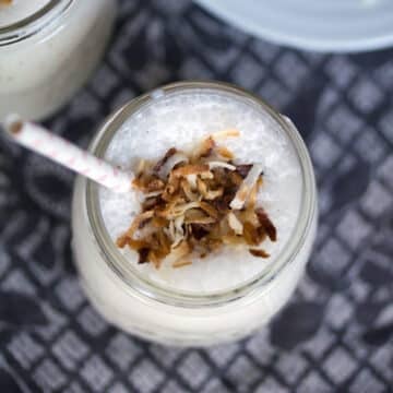 Overhead view of a vanilla coconut milkshake with toasted coconut on top.