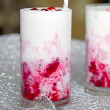 Closeup view of two vanilla cranberry milkshakes.