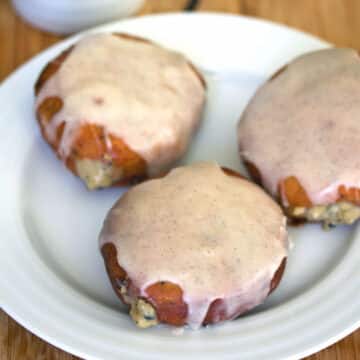 Closeup view of a plate of vanilla latte donuts with icing and custard filling.
