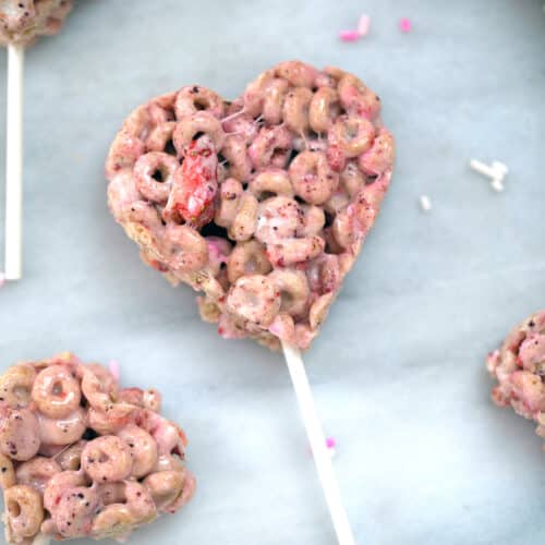 Closeup overhead view of heart-shaped Very Berry Cheerios treat pops on sticks.