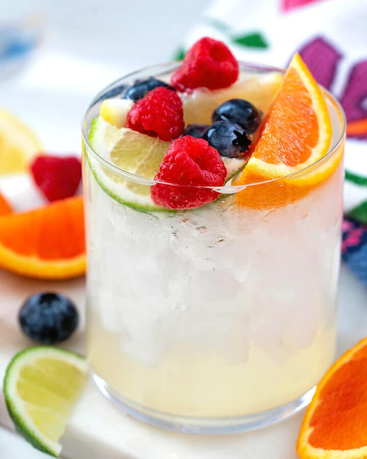 Close-up view of a vodka seltzer topped with lots of fruit.