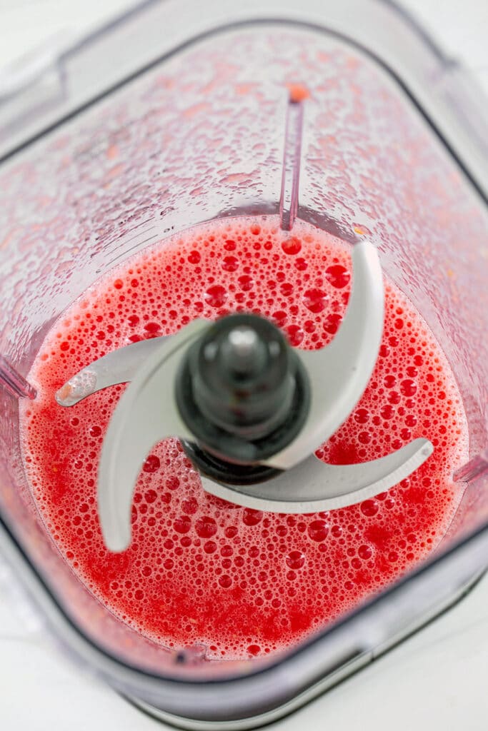 Overhead view of watermelon pureed into juice in blender.