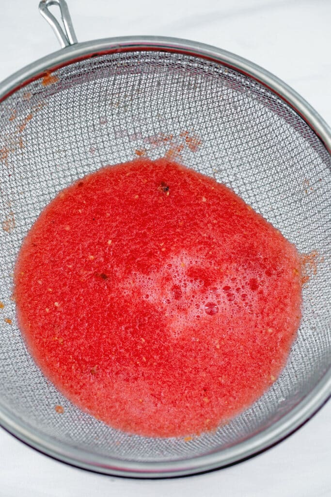 Watermelon juice going through strainer.