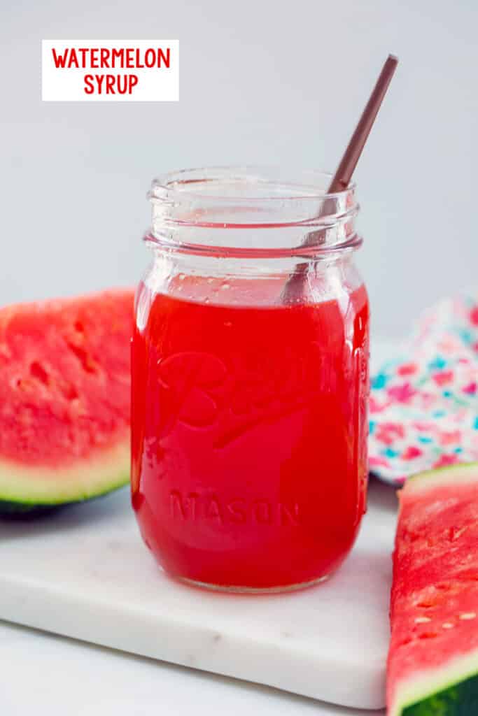 Mason jar of watermelon syrup with spoon in it with slices of watermelon in background and recipe title at top.