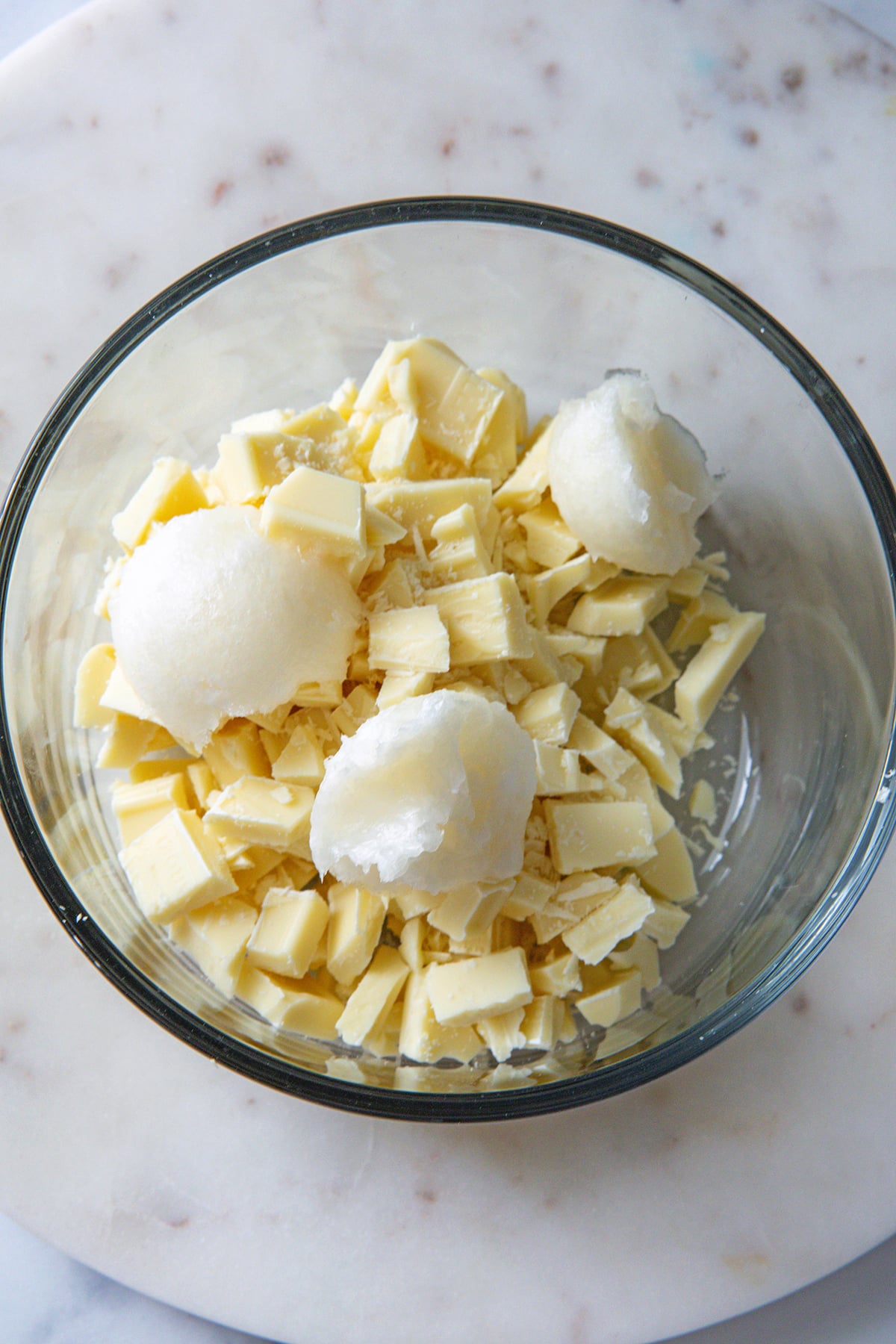 Chopped white chocolate and coconut oil in a small bowl.