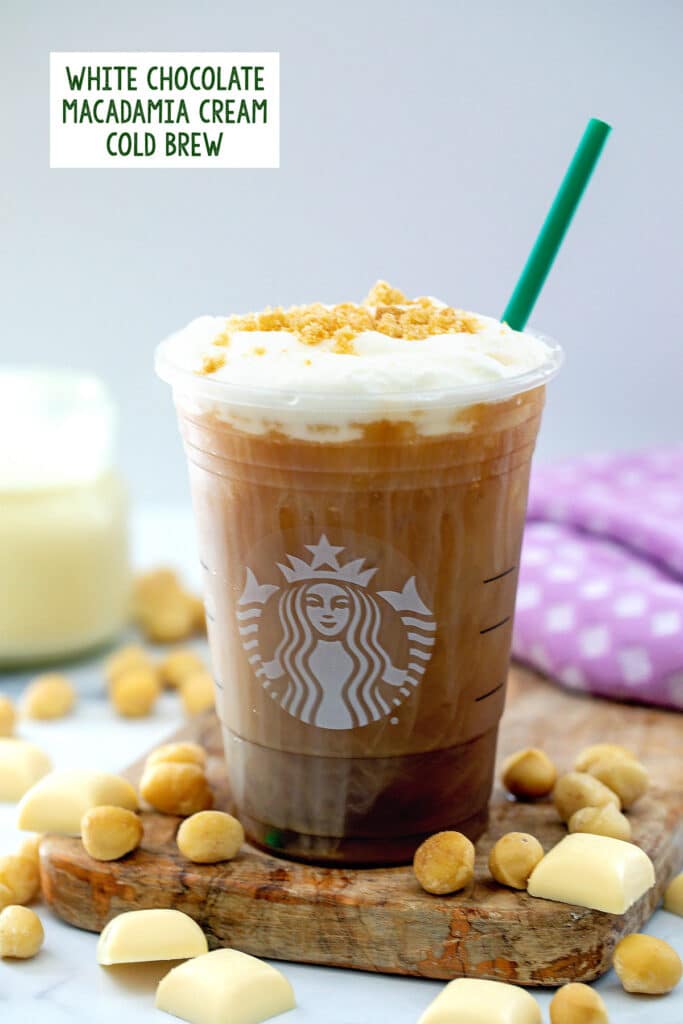 Head-on view of White Chocolate Macadamia Cream Cold Brew in Starbucks cup with macadamia nuts all around and recipe title at top.