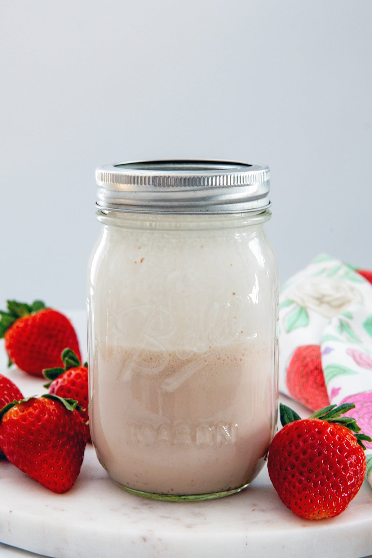 Head-on view of a mason jar filled with white chocolate strawberry cold foam.