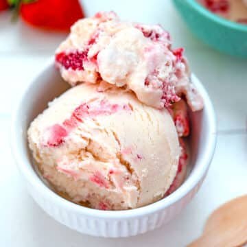 Closeup view of a bowl of strawberry white chocolate ice cream.