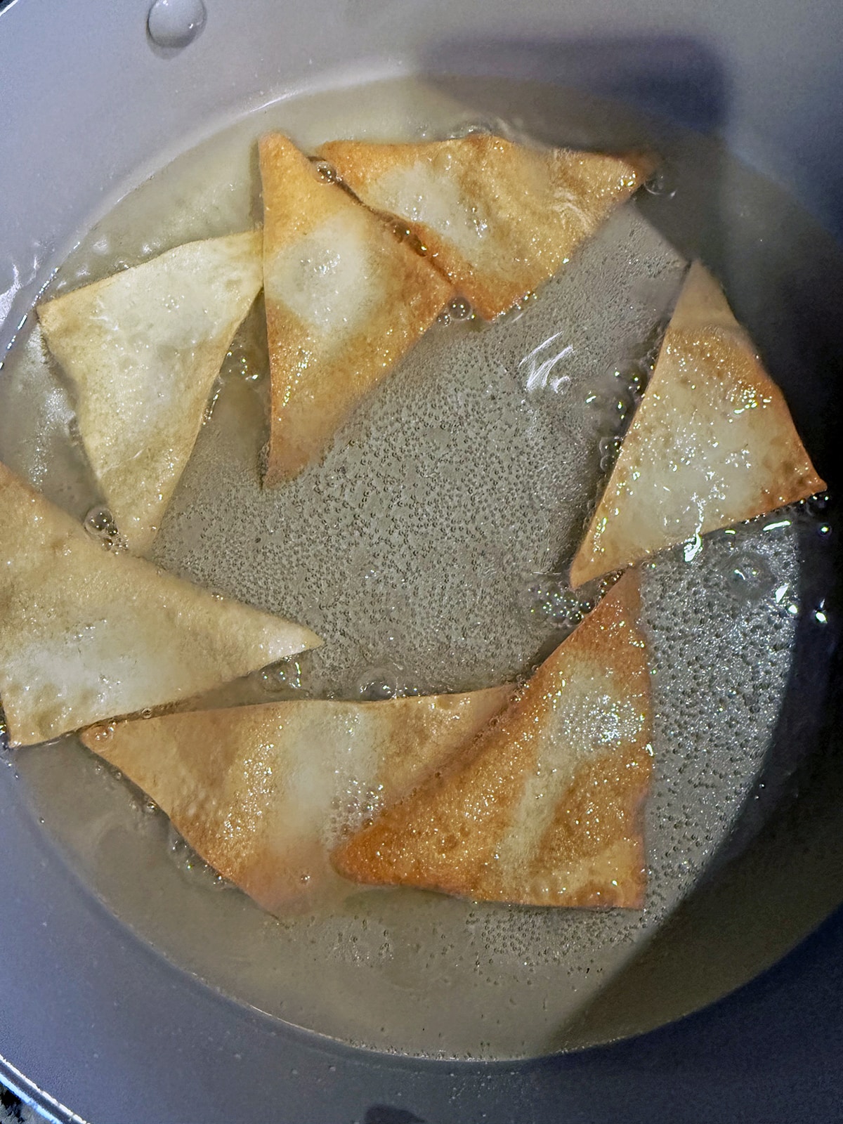 Wonton chips frying in oil.