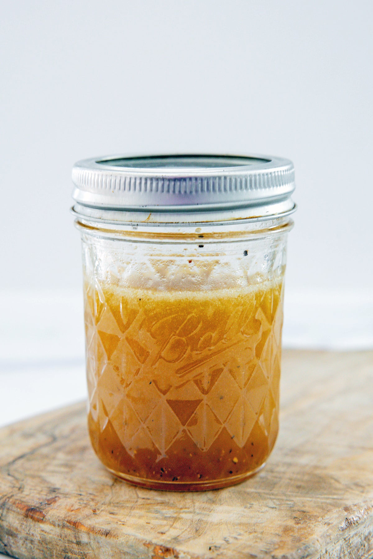 Zesty apple cider vinaigrette in small mason jar.
